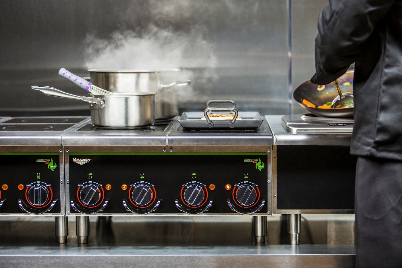 Chef cooking on induction range stovetop