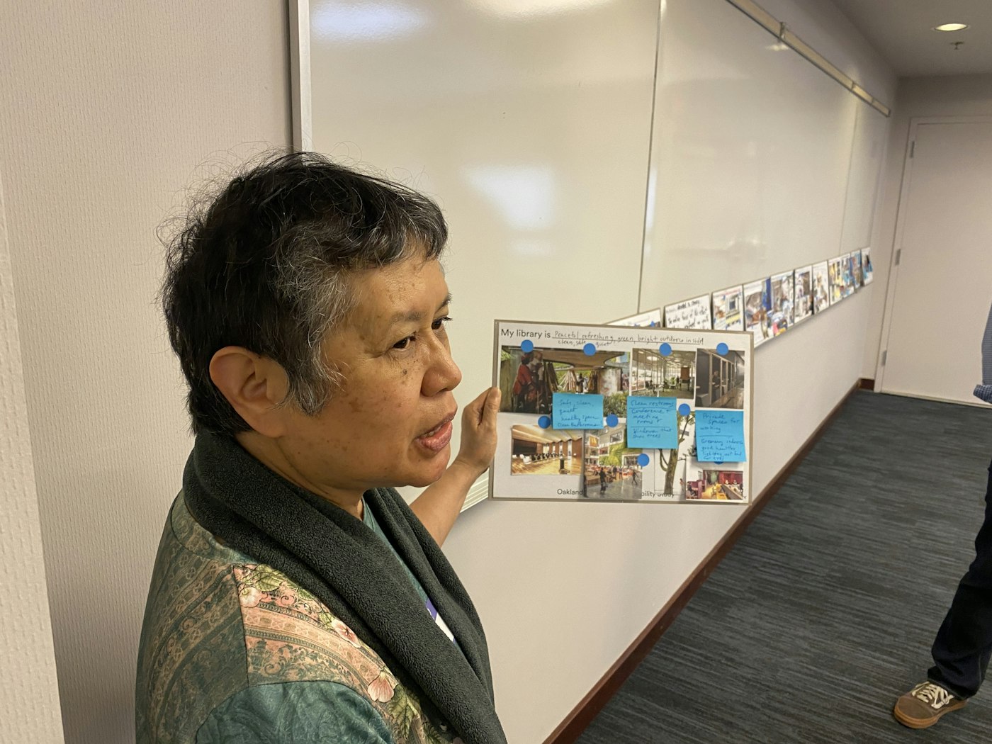 Workshop participant holds up a printed item with sticky notes attached to it.