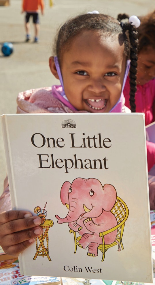 Girl holding One Little Elephant book
