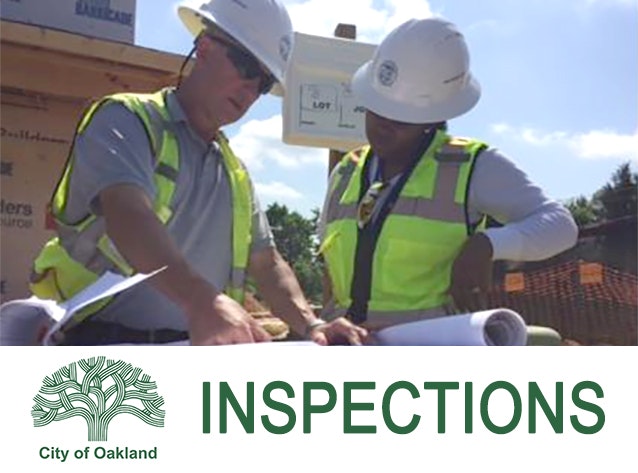 Photo of building inspectors looking at project plans at job site